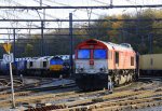 Die Class 66 PB03  Mireille  von Crossrail steht in Montzen-Gare(B) mit einem sehr langen Fiat-Autozug und auf dem Nebengleis steht die Class 66 DE6306 mit einem sehr langen Containerzug bei schne Novembersonne am 25.11.2012.