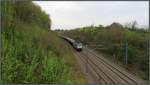 Der Blick auf die Montzenroute bei Nouvelaer in Belgien am 03.April 2014. Eine Cobra
(E-186) kommt gerade mit einen langen Kesselwagenzug aus Richtung Montzen vor die Linse gefahren.