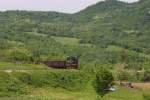 Die bosnische Kennedy Diesellok 323 ist hier mit einem Leerzug in den Bergen  bei Spionica am 20.5.2011 in Richtung Tuzla unterwegs.