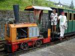 Diema-Lok DS28 Nr. 2556 in orange und rot, mit Personenwagen aus Holz und posierenden Touristen im Bahnhof Pequea Helvecia, 05. Mrz 2006