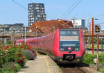 Rote Blumen mit rotem Zug im Bahnhof Oesterport in Kopenhagen. Kopenhagen, 18.06.2019