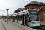 Aarhus Letbane: Stadler Variobahn 1110-1210 hält als RegioTramlinie L2 am 10. Juli 2020 im Bahnhof Odder. - Leute ohne ein näheres Wissen über Bahnen im Nahverkehr stellen oft die Frage: Was ist eigentlich der Unterschied zwischen einer Straßenbahn (dä: sporvogn) und einer Stadtbahn (dä: letbane)? Wenn man dann einen modernen Straßenbahnwagen wie die Stadler Variobahn betrachtet, könnte man eigentlich ruhig antworten: Es gibt keinen Unterschied - ein moderner Straßenbahntriebwagen kann als Stadtstraßenbahn, Überlandstraßenbahn / RegioTram, als ober- oder unterirdische Stadtbahn in Betrieb gesetzt werden. Der Aufbau des Neztes, Geschwindigkeitswünsche, die Anlage und der Haltestellenabstand können danach eine Rolle spielen, ob man das System eher als Straßenbahn oder Stadtbahn einrichten will. - In der zweitgrößten Stadt Dänemarks, Århus, hat man eine Mischung der  Bahnarten  zugestrebt. In der Stadt fahren die Triebwagen der Aarhus Letbane, sowohl die Variobahnen auf der Linie L2 als auch die Stadler Tango der Linie 1, als Straßenbahnen mit kurzen Abständen zwischen den Haltestellen, auf der Strecke Århus - Odder hat man gewahlt, die Straßenbahntriebwagen des Typs Variobahn als Überlandstraßenbahn / RegioTram auf einer ehemaligen Eisenbahnlinie einzusetzen, obschon diese eine Höchstgeschwindigkeit von 80 Stundenkilometern haben, während man auf der ehemaligen DSB-Strecke Århus - Grenå die Stadler Tango mit einer Höchstgeschwindigkeit von 100 Stundenkilometern benutzt. -
Im Hintergrund des Bildes kann man die ehemalige Werkstätte der Odderbanen undeutlich sehen. Hinter dem Straßenbahntriebwagen befindet sich rechts ein paar Museumseisenbahnwagen. 