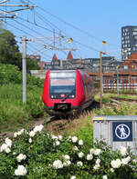 Weisse Blumen mit rotem Zug im Bahnhof Oesterport in Kopenhagen.