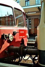 Zwei Akkuzüge der DB-Baureihe 515/815 in verschiedenen Farben im Augsburger Hauptbahnhof.