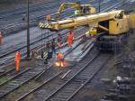 Knochenjob bei schlechtem Wetter, Gleisarbeiter  beim zusammenbau einer Doppelkreutzweiche am Aachener Westbahnhof.