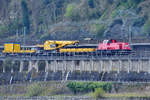 Die baneservice-Diesellokomotive 261 005-3 zieht einen Kirow-Kran von Hering Bahnbau, so gesehen Mitte April 2021 bei Remagen.