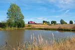 Eine V100 Ost mit einem kurzen Bauzug bei Oberteich Richtung Marktredwitz, 12.08.2018