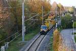 Bauarbeiten zur Elektrifizierung der Bodenseegrtelbahn, Streckenabschnitt Friedrichshafen - Lindau. Zweiwege-Unimog mit Fahrleitungsmontagewagen und Verlegeeinheit am 25.10.2019 bei der Haltestelle Friedrichshafen-Ost.