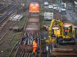 Hier werden am Westbahnhof Aachen die zerlegten Teile einer ausgetauschten Doppelkreutzweiche mit einem 2Wegebagger auf einen Bauzug der Fa.