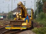 Ein Atlas 2Wegebagger von Eiffage Rail schiebt einen Anhnger mit Werkzeug ganz langsam ber eine Weiche am 07.10.2010 in Aachen West. Der Arbeiter auf dem Anhnger nutzt die kurze Fahrt bei schnem Herbstwetter fr eine Zigarettenpause.