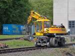 Ein Zweiwegebagger von Schweerbau rumt in Aachen West am 22.04.2011 an dem Gleisanschlu vom Institut fr Schienenfahrzeuge (IFS) der RWTH Aachen ausgebaute Holzschwellen zusammen.