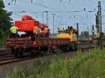 Ein Zweiwegebagger von Balfour Beatty ist am 13.08.2012 mit einem vierachser Flachwagen auf dem eine fahrbare Arbeitsbhne steht in Aachen West unterwegs.