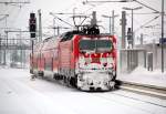 Vom harten Winterdienst gezeichnet erreicht eine BR 143 mit dem RE von Mageburg Hbf nach Leipzig Hbf den Bahnhof Bitterfeld.