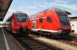 Hier links 442 142-6 als RB11 (RB18220) von Cottbus nach Frankfurt(Oder) und rechts eine leere RE1-Garnitur mit Schublok 112 122, diese beiden Züge standen am 25.7.2015 in Cottbus.