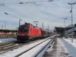 Ein Taurus der BB zieht einen Railjet durch den Freilassinger Bahnhof.