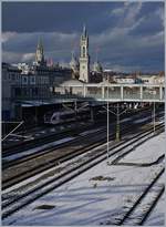 Während der Seehas Flirt sich am schattigen Bahnstieg  versteckt  leuchtet die Skyline von Konstanz im schönsten Sonnenlicht.