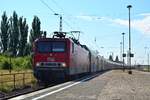 143 175-8 passiert mit einem Autozug den Bahnhof Köthen gen Magdeburg.