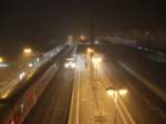 Blick vom  Kleppersteg  auf die im Nebel liegenden Bahnsteige des  Bahnhofs von Rosenheim.