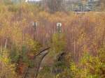 Im bunten Herbstwald auf dem ehemaligen BW Wedau sind die Gleise noch recht fei und mal erkennt noch an vielen Orten die Signale da hier nichts abgebaut wurde. Hier zu sehen sind 2 Form Vorsignale. Bis 2004 war hier noch Beitrieb. Als auch das AW Wedau geschlossen wurde begann der Untergang von Wedau.

Duisburg Wedau 14.11.2015