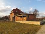 Das Bahnhofsgebude in Laucha (Unstrut) am 28.02.2015, mit den Resten der Gterverladerampe.