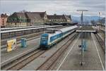 Die 223 069 wartet in Lindau mit ihrem Alex nach München auf die Abfahrt, die jedoch fahrplanmäßig erst in gut ein-einhalb Stunden vorgesehen ist. Im Hintergrund das schöne Bahnhofgebäude von Lindau. 
16. März 2018
