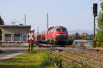 218 417-4 schiebt ihren IRE aus Friedrichshafen kommend auf den Bahndamm.