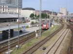 Blick auf die Gleisanlagen von Mnchen Hbf von der Hackerbrcke aus. Links ist die S-Bahn-Haltestelle Hackerbrcke zu erkennen. Eine S-Bahn kommt gerade aus dem S-Bahn-Tunnel heraus, eine fhrt gleich hinein. Die Aufnahme entstand am 18.07.2004.