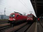 Die BR 182 mit dem Fuballsonderzug neben der BR 101 105, die an einem IC hngt. Fast kaum erkennbar: Der Tf der 182 hlt ein Zuglaufschild fr die RE-Linie 10 Leipzig-Cottbus ans Fenster. Eine Anspielung auf das aktuelle Einsatzgebiet der BR 182
Rostock, 14.12.09