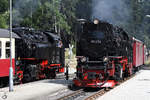Die Dampflokomotive 99 236 fährt in den Bahnhof Schierke ein, 99 222 wartet auf die Weiterfahrt in Richtung Wernigerode.