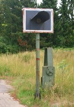 Von der Eisenbahn blieb in Zernien nicht viel mehr brig als ein Blinklicht und ein Schrankenantrieb (Bahnbergang  Ghrdestrae  am 11.07.2015). Die hier kreuzende Strecke Uelzen–Dannenberg verlor ihren Personenverkehr bereits 1975 und wurde zum 01.06.1996 stillgelegt.