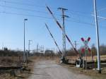 Bahnbergang an der Strecke Stralsund-Neustrelitz am Abzw Stralsund Rgendamm am 22.Mrz 2011.Die Bedienung der Schranke erfolgt vom Stellwerk  Srg  aus.