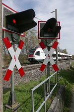Bahn und Sicherungstechnik - Kurz nach Abfahrt in Allensbach passiert der Seehas auf der Fahrt nach Engen am 03.04.2016 den auf Grund der Straßenführung mit zwei Blinklichtern auf einer Seite ausgerüsteten Bahnübergang.