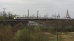 ICE 1604/1704 (Tz Torgau ziehend, Tz Passau hintan) beim Verlassen der Elbbrücke zu Wittenberg Richtung Berlin im Gegengleis (wegen der Überholung einer S8). Im Vordergrund die B 187 und die KBS 216 aus Dessau.
Aufgenommen vom  Bunkerberg .

Wittenberg, der 11.04.2025