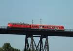 Mit einem demolierten Steuerwagen im Schlepp befährt 218 333-3 am 28.8.14 die Rendsburger Hochbrücke.