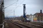 Nicht oft befindet sich ein Spundbohlensetzer auf dem Planum eines Bahndammes.
Am 14.03.12 gegen 14:00 Uhr werden als brckenbauvorbereitende  Manahme Spundbohlen eingbracht, der Fotograf  schaut  von Radebeul Ost Richtung Trachau, links ist das derzeit einzig zu befahrende Streckengleis zu erkennen.