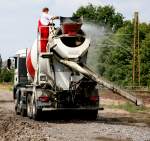 Nachdem der Beton fr den Kopf der Spundbohlenwand abgekippt war, konnte der Fahree  des Stetter Mischfahrzeuges die Zeit nutzen , sein Fahrzeug auf dem Bahndamm zu reinigen.