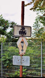 Dieses nur noch in Teilen erhaltene Schild vor dem WDI Werk Rothenburg (Westfälische Drahtindustrie) warnt vor fahrenden Zügen auf dessen Gelände.