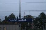 Hier das Bahnhofsschild von Frankfurt Sd mit dem Commerzbank Tower im Hintergrund.