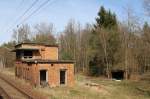 12.4.2015 Ehem. Stellwerk in Km 113 der Dresdener Bahn. Ein Blick auf google-maps zeigt, dass hier mal ein Gleis in südwestlicher Richtung abbging - ziemlich sicher Militärgelände. Auch interessant: Der Schuppen im Hintergrund muss mal ein alter Wagen gewesen sein - halbrundes Dach und Metallrahmen mit Nieten sprechen dafür... Aus vorbeifahrenden RE3 aufgenommen.