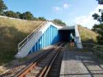 Die Usedomer Bäderbahn unterquert,an der Station Wolgast Fähre,in einer tunnelartigen Unterführung,die Bundesstraße 111.Hier in Richtung Zinnowitz.Aufgenommen am 24.August 2014.