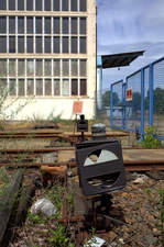 Blick durch den Gitterzaun mit der Festbrennweite auf eine etwas desolate Gleissperre.
