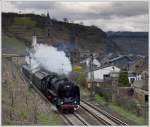 01 118 mit ihrem DRG-Schnellzug von Koblenz nach Trier am 3.4.2010 wenige Meter vor der Durchfahrt der Station Hatzenport an der Mosel. Im Hintergrund ist die Pfarrkirche St. Rochus zu sehen, dahinter die alte kath. Pfarrkirche St. Johannes.
