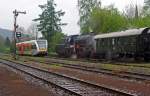 Alt trifft Modern am 06.05.2012 bei Regen im Bahnhof Herdorf (Kreuzungsverkehr): Auf Gleis 1 hat die 23 042 vom Eisenbahnmuseum Darmstadt-Kranichstein Hp 0 und wartet zur Weiterfahrt nach Betzdorf, auf Gleis 2 fhrt ein GTW 2/6 der Hellertalbahn (Betzdorf - Dillenburg) ein.