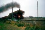 BR 43 vor einem Gterzug auf der Emslandstrecke bei Rheine, die Fahrleitungsmasten stehen schon..... (es kann natrlich auch eine 042 gewesen sein, das wei ich leider nicht mehr, dieses Dia stammt aus den Siebziger Jahren)