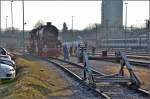 Winterfahrt zu den Eidgenossen (II). Parkplatz nebst Parkplatz. In Konstanz gibt es da keine Berührungsängste... Die 52 der Eisenbahnfreunde Hohenzollern wartet auf ihren Zug und die Passanten finden es spannend. Im Hintergrund sagt die SBB das Motto an...