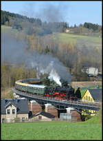 UEF 58 1111 (NVR: 90 80 0058 311-6 D-UEF) am 18.04.2026 mit dem GleisGlück-Sonderzug DZ 88724 Chemnitz - Schlettau - Chemnitz. Die 1921 gebaute Dampflok (MBG - Maschinenbau-Gesellschaft Karlsruhe, Fabriknummer: 2153) war auf ihrer ersten Erzgebirgsrunde unterwegs und arbeitete sich hier über die bekannte Schwimmbad-Brücke die Steigung nach Scheibenberg hinauf. Am Schluss schob die grün-weiße V100 003 (NVR: 92 80 1201 003-1 D-DB, DB Museum Nürnberg) den aus acht Wagen bestehenden Zug nach.