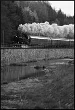 PRESS 86 1744-1 dampfte am frühen Morgen des 18.04.2026 mit dem exPRESSzugreisen-Sonderzug Chemnitz - Aue - Karlsbad (Karlovy Vary) in Einsiedel an der Stützmauer der Zwönitz entlang.