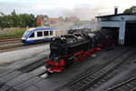 Drei Barbelsberger Neubaudampfloks, im Vordergrund die frisch aus Meiningen zurück gekommene 99 7241-5, stehen im BW Wernigerode während ein Lint des HarzElbeExpress auf den Normalspurgleisen in den Bahnhof der DB einfährt.

Wernigerode, 04. August 2017