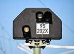 Hier eine Detailaufnahme des Schutzsignals (Sh-Signal)  95 202X , mit dem Signalbild  Sh 1  (Rangierfahrtsignal). 
(Laut DV 301 wird dieses Signalbild auch als  Ra 12  geführt.)
Dieses steht am Haltepunkt  Lübeck-Dänischburg IKEA  (ALD A).