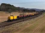 Eine V 100 Ost von SGL mit einem Schotterzug am 17.03.2012 unterwegs bei Harrbach.